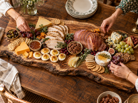 Southern holiday grazing spread on a handcrafted hardwood board with meats, cheeses, fruit, bread, and seasonal accents