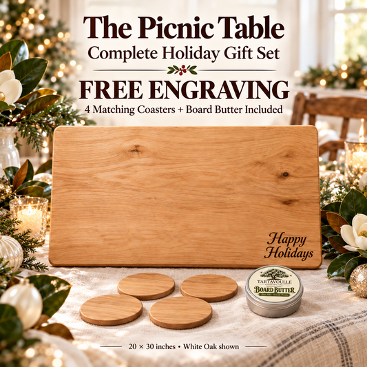 The Picnic Table 20" × 30" Complete Holiday Gift Set, engraved board with four matching hardwood coasters and Board Butter in a Southern white Christmas setting.